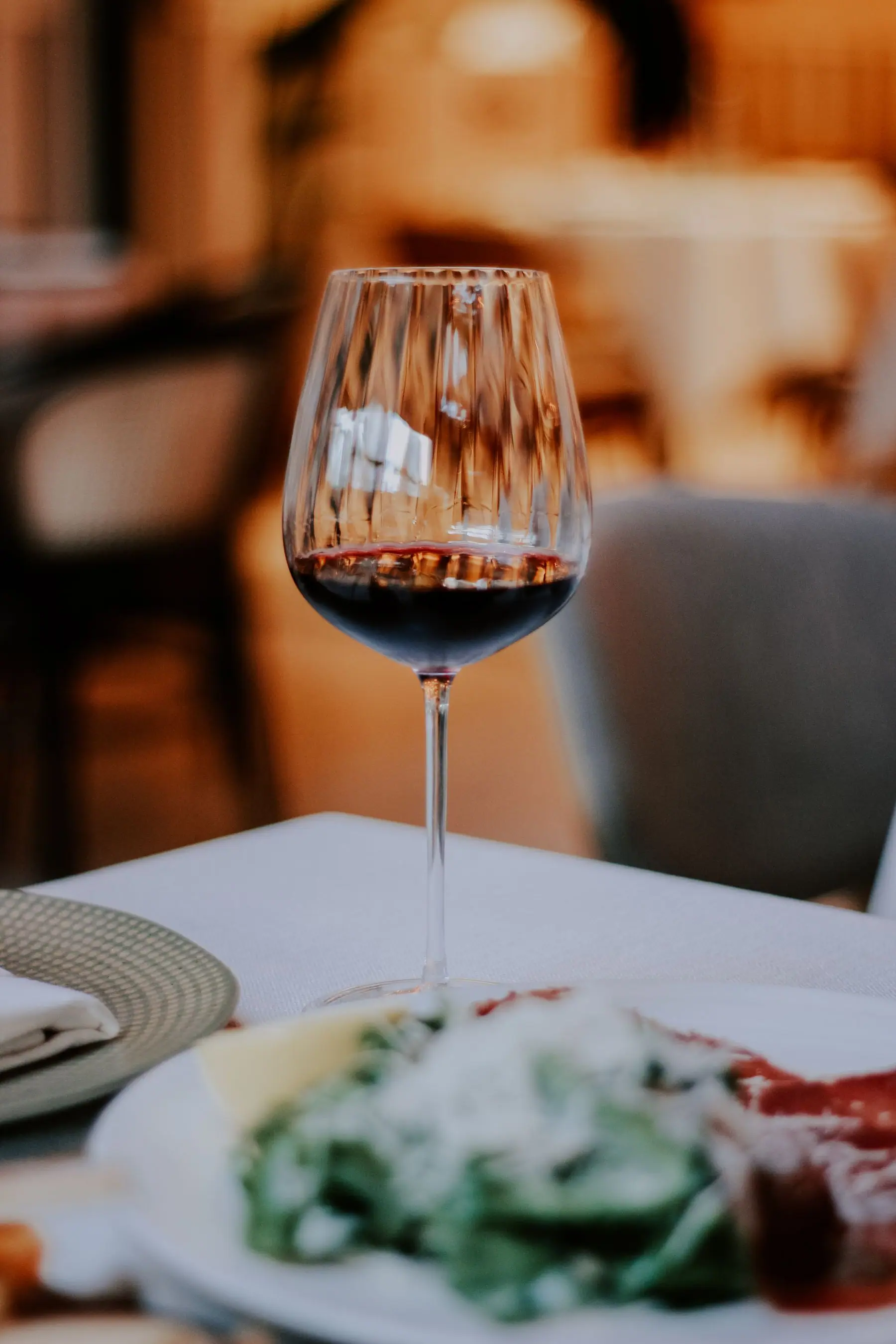 Un bicchiere di vino rosso su un tavolo apparecchiato