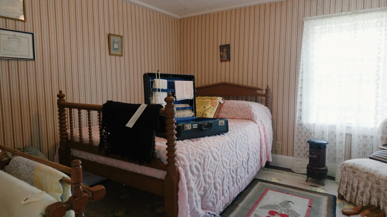 Una camera d’epoca con la valigia sul letto, e la luce della finestra